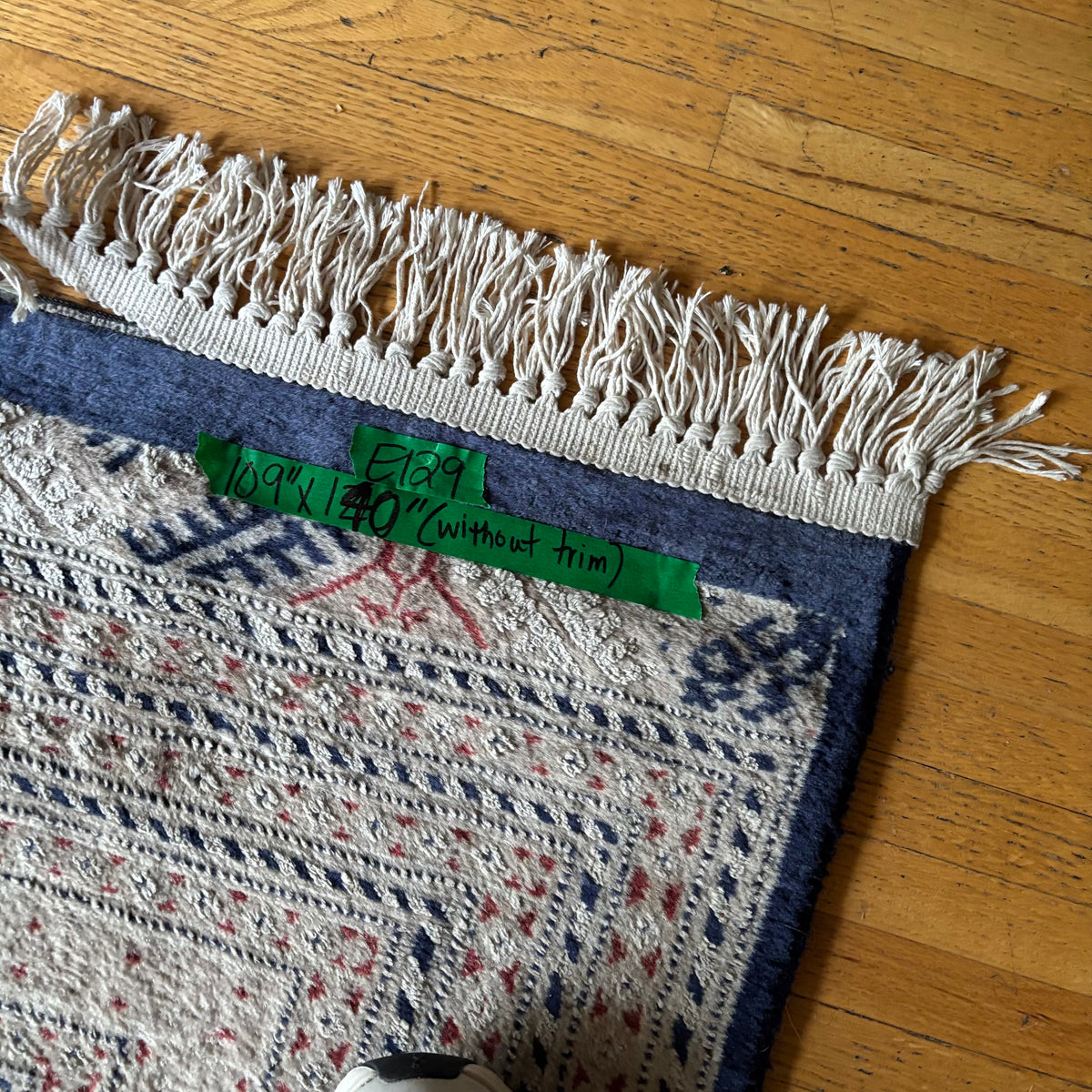 E129 109” x 150” Vintage wool rug with underlay (fringe is mostly separated)