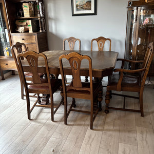 Antique oak dining table with tressel style base, built in leaf and and 6 chairs (1 chair is loose at the top) - O482