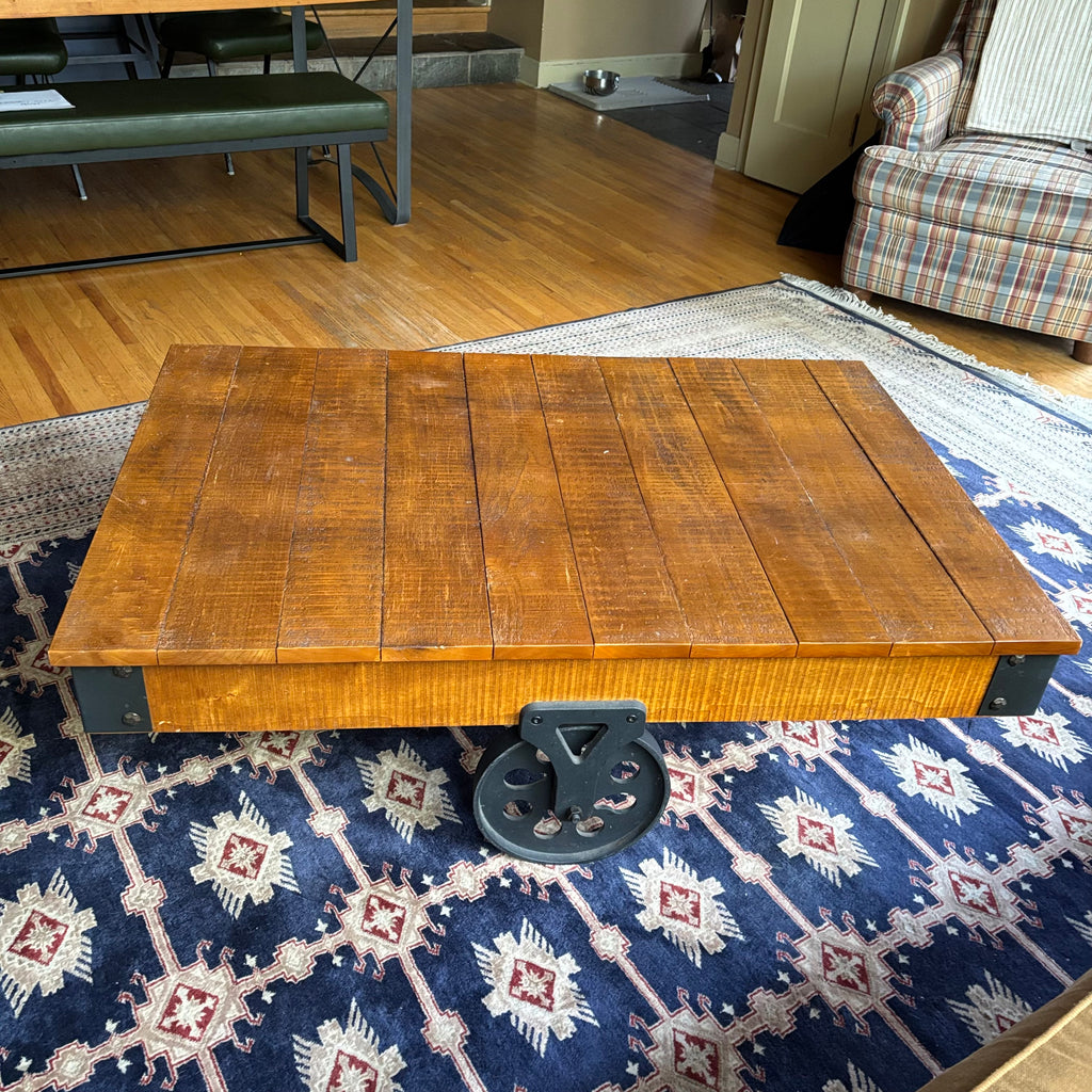 E128 Coffee table with industrial wheels (16” x 47” x 31”) **one wheel is slightly bent