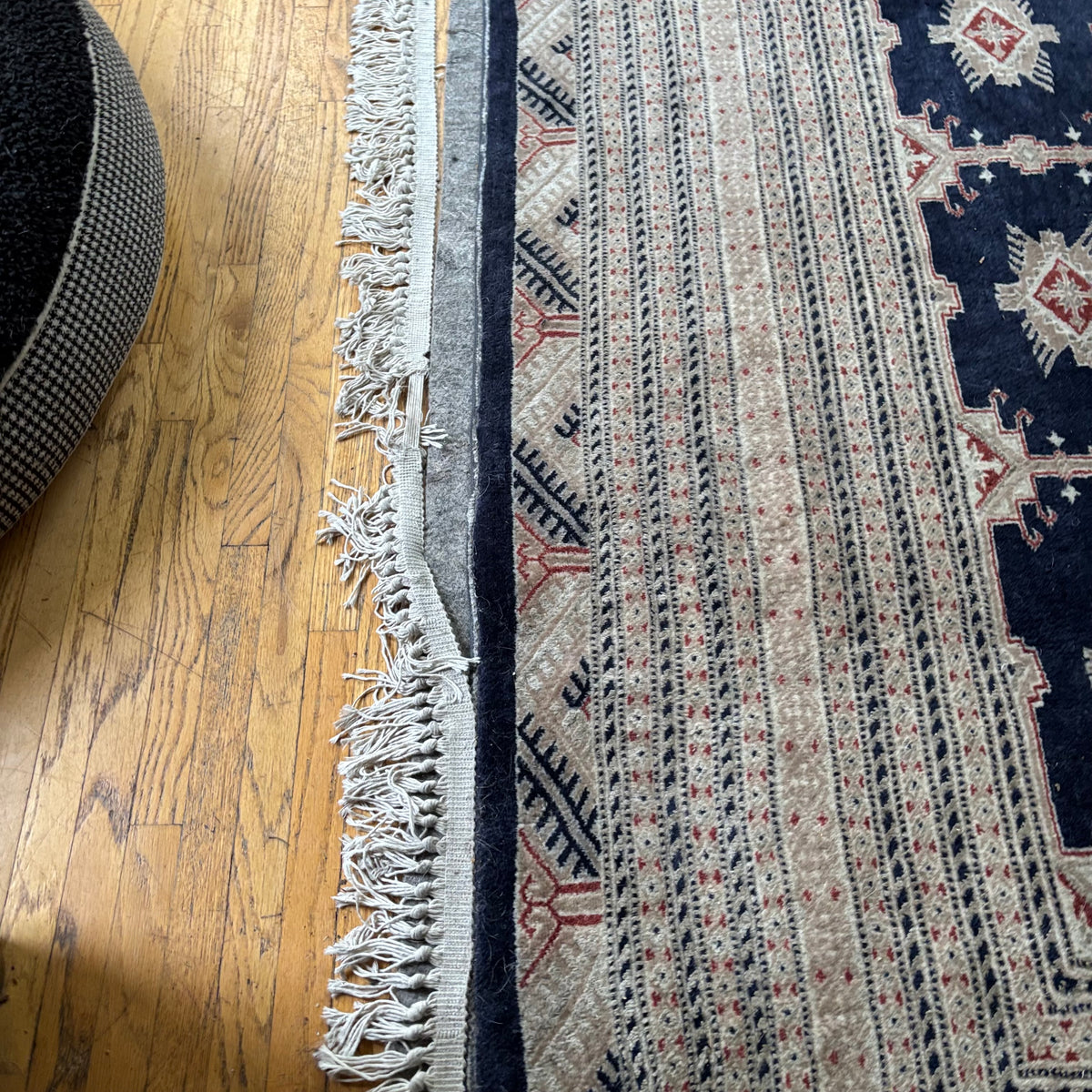 E129 109” x 150” Vintage wool rug with underlay (fringe is mostly separated)