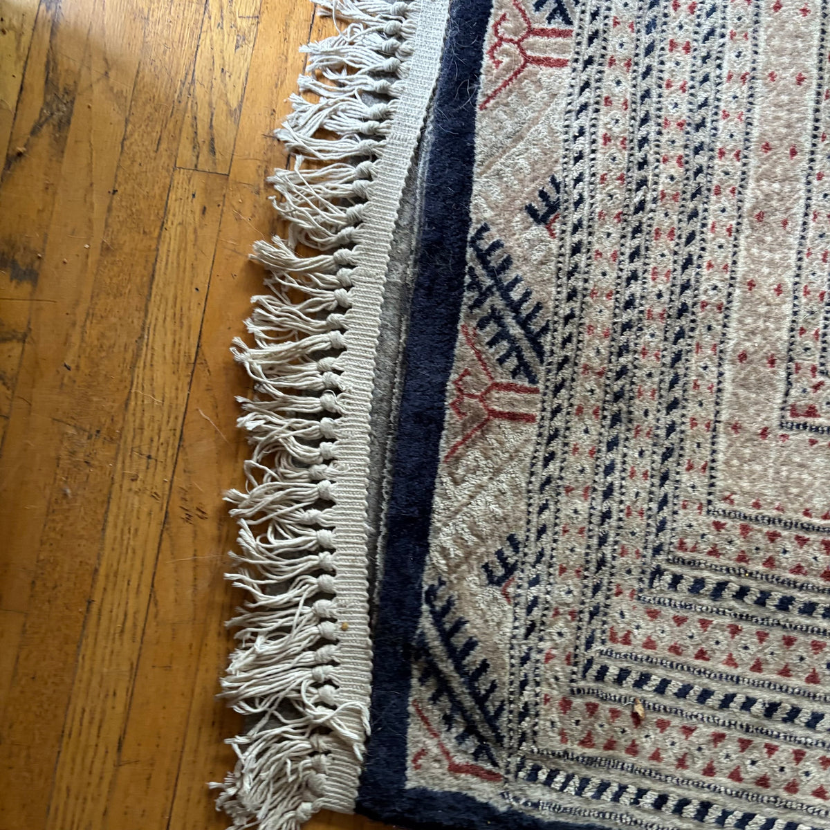 E129 109” x 150” Vintage wool rug with underlay (fringe is mostly separated)