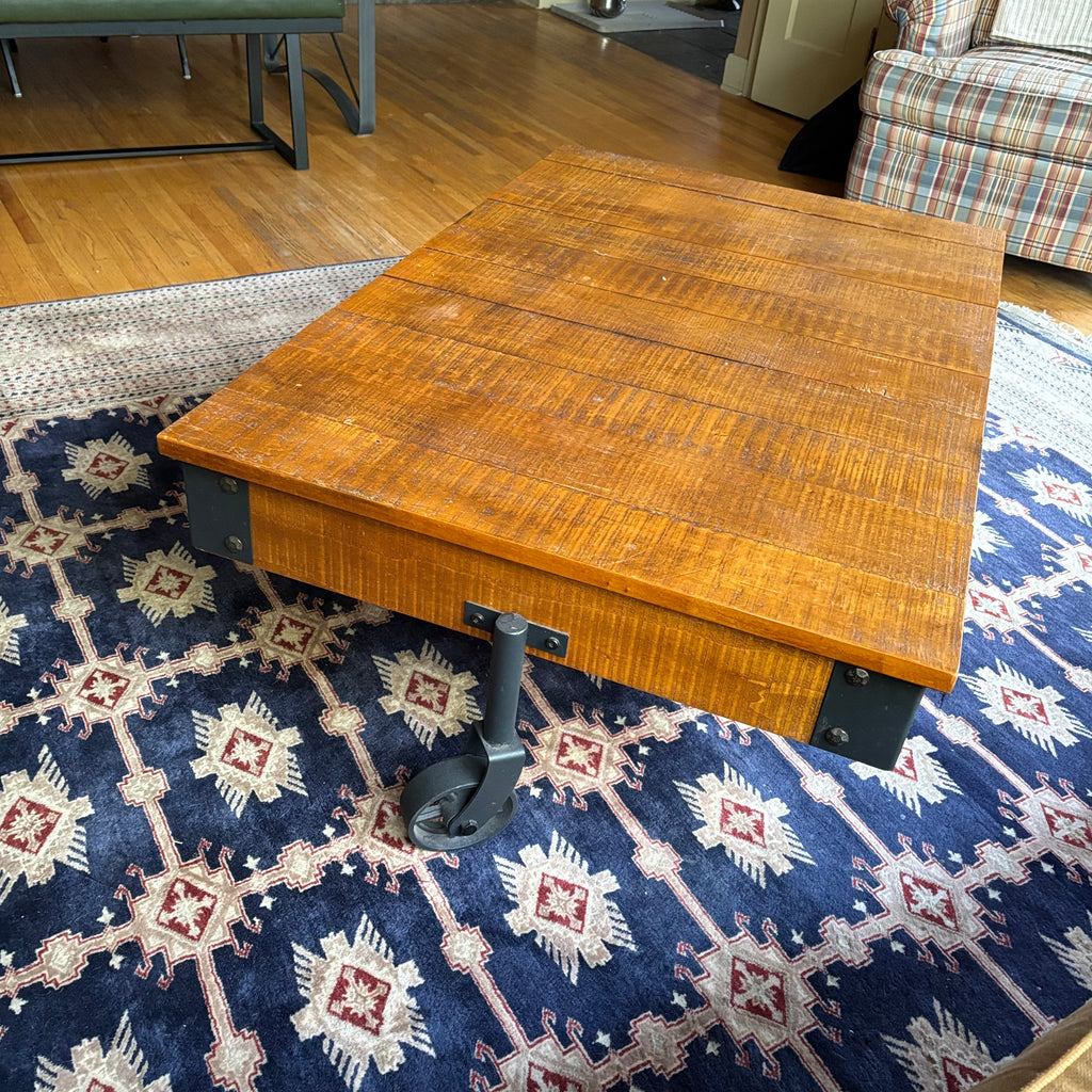E128 Coffee table with industrial wheels (16” x 47” x 31”) **one wheel is slightly bent
