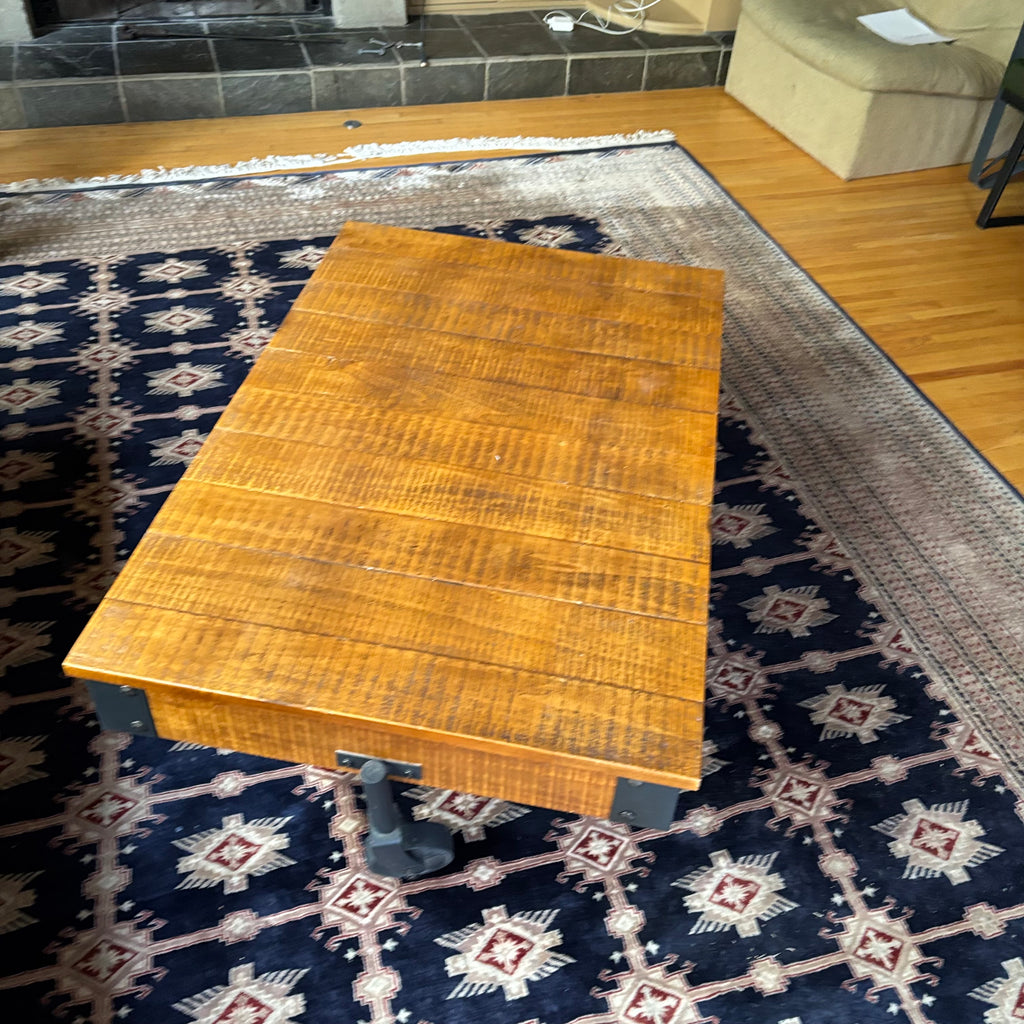 E128 Coffee table with industrial wheels (16” x 47” x 31”) **one wheel is slightly bent