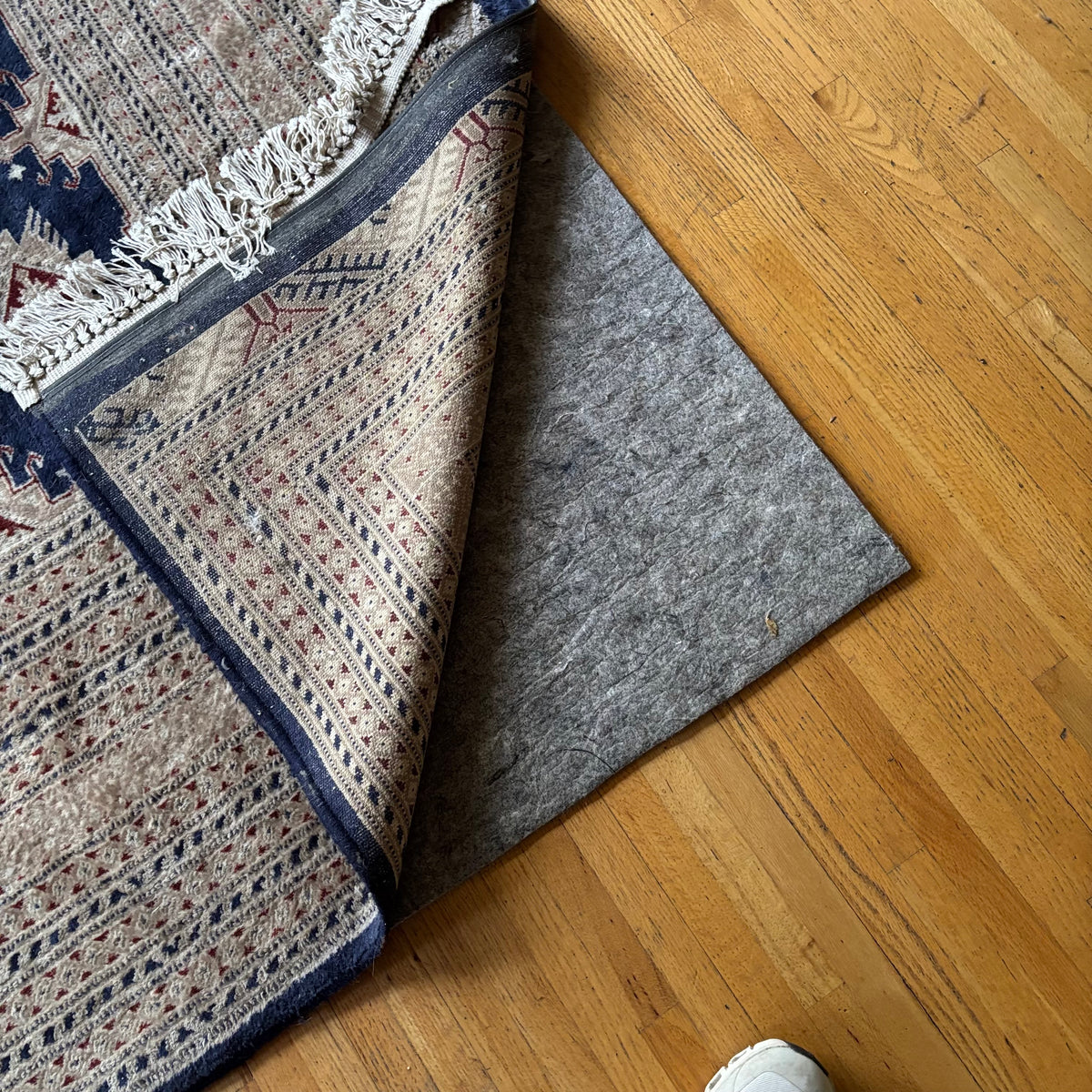 E129 109” x 150” Vintage wool rug with underlay (fringe is mostly separated)